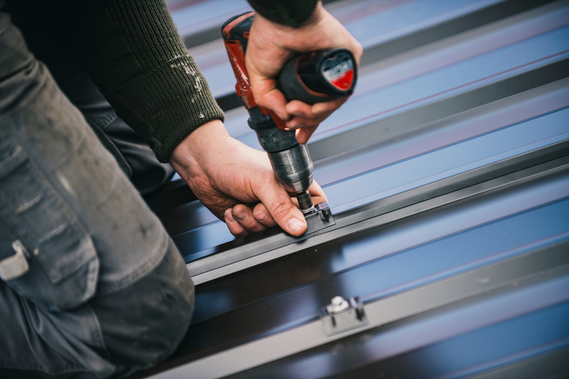 Building contractor is installing metal roofing sheets